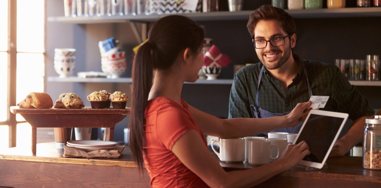Coffee shop worker helping customer with transaction. Coffee shop worker helping customer with transaction.