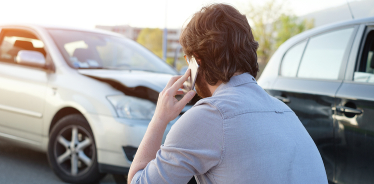 Man on cell phone at a car accident. Man on cell phone at a car accident.