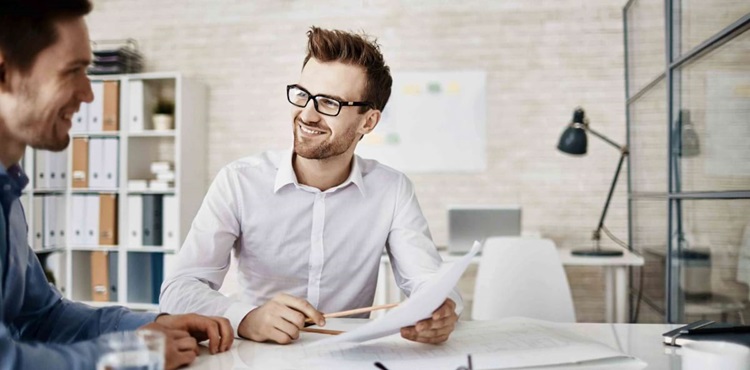 Consultant reviewing notes with his client. Consultant reviewing notes with his client.