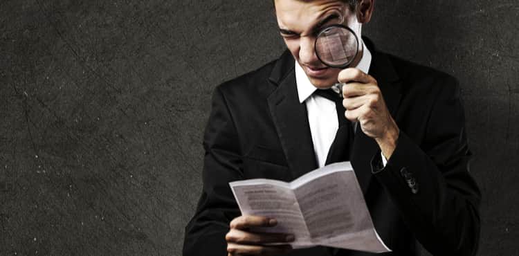 Man looks at book through magnifying glass. Man looks at book through magnifying glass.
