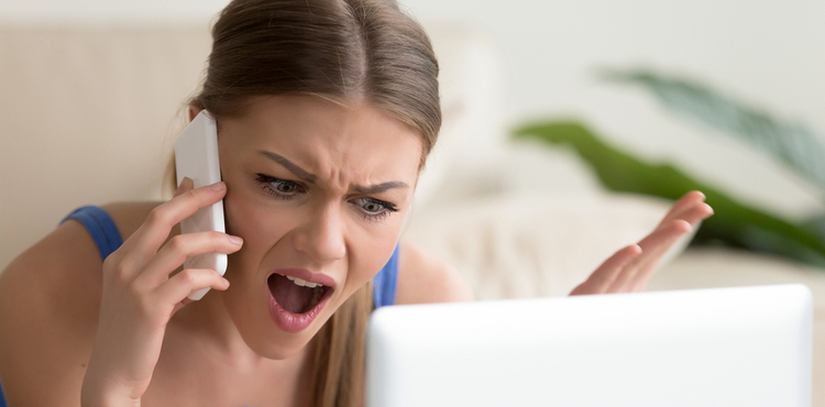 A woman gestures angrily while talking on the phone. A woman gestures angrily while talking on the phone.