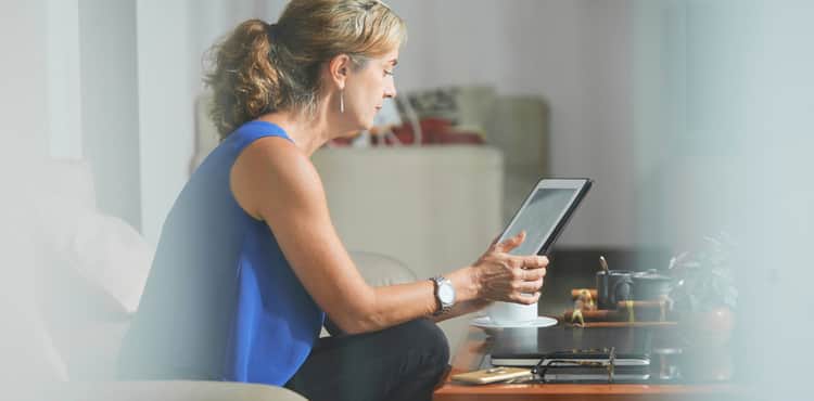 Older woman working on tablet from home. Older woman working on tablet from home.