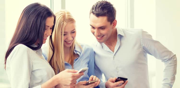 Three young people staring at their phones. Three young people staring at their phones.