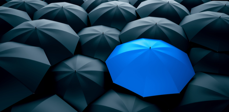 A blue umbrella in a sea of black umbrellas. A blue umbrella in a sea of black umbrellas.