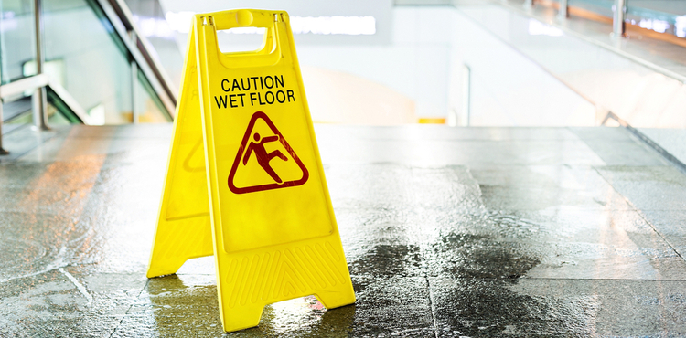 A wet floor sign placed at the top of a staircase. A wet floor sign placed at the top of a staircase.