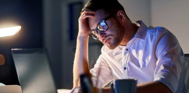 Frustrated man sitting at desk looking at his computer. Frustrated man sitting at desk looking at his computer.