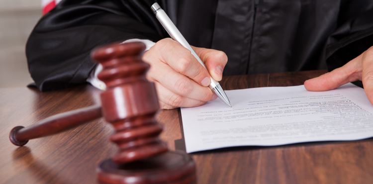 Judge sitting at desk signing documents. Judge sitting at desk signing documents.