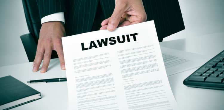 Man in suit hands over notice of lawsuit. Man in suit hands over notice of lawsuit.