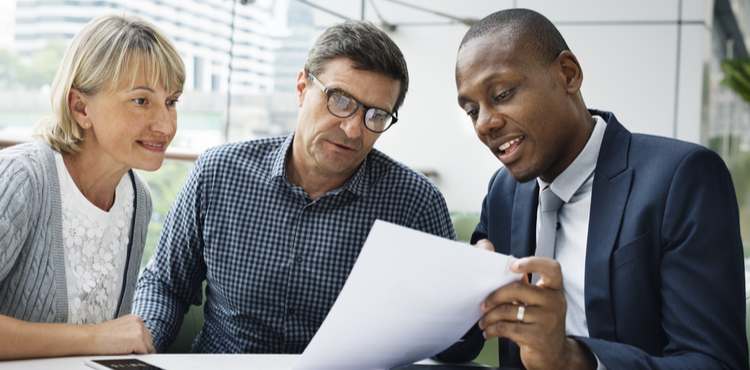 Man and woman discuss document with businessman. Man and woman discuss document with businessman.