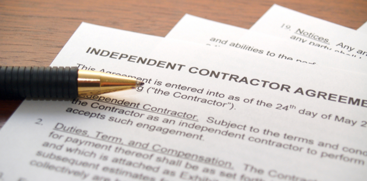 An independent contractor agreement and pen. An independent contractor agreement and pen.