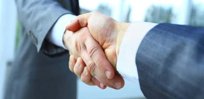 Men in suits shake hands. Men in suits shake hands.
