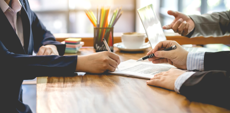 Three business people discuss and sign a contract. Three business people discuss and sign a contract.