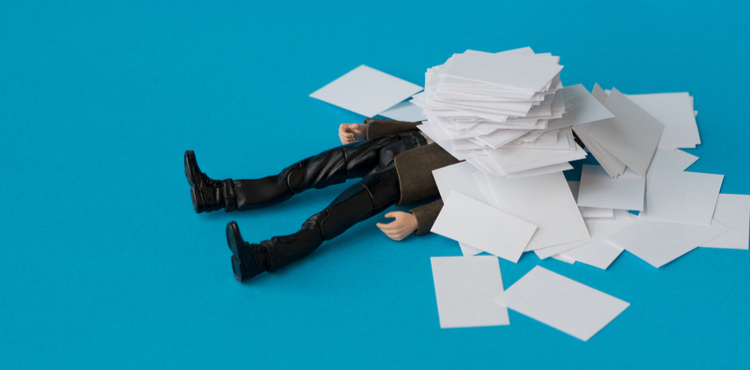 A toy man drowns in a pile of paperwork. A toy man drowns in a pile of paperwork.