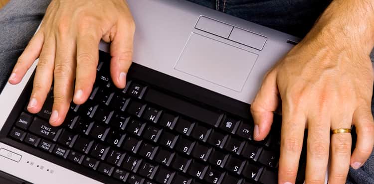 Man sits on floor and types on keyboard. Man sits on floor and types on keyboard.