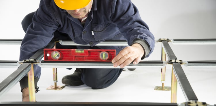 A construction worker installed a raised-access floor. A construction worker installed a raised-access floor.
