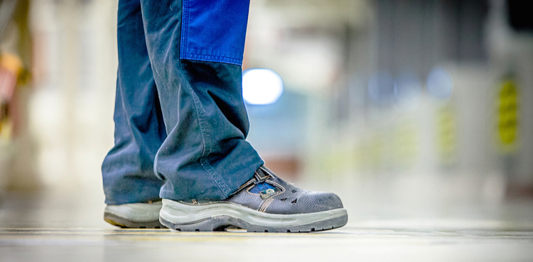 Standing worker wearing appropriate shoes. Standing worker wearing appropriate shoes.