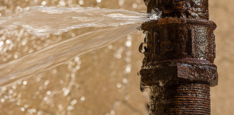 A burst pipe on a brown background. A burst pipe on a brown background.