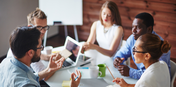 A team of business people meet around a table. A team of business people meet around a table.