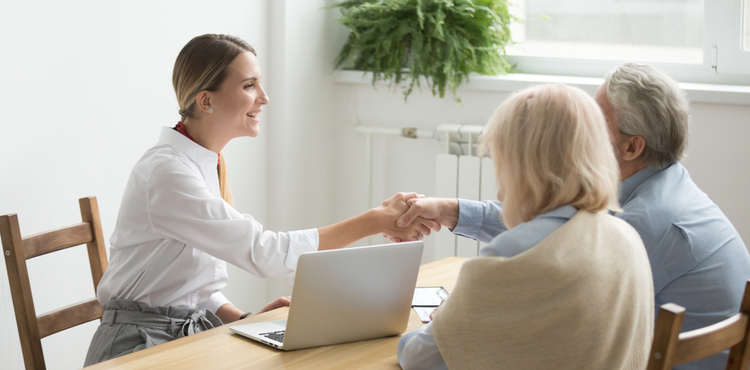 Business woman shakes hands with elderly clients. Business woman shakes hands with elderly clients.
