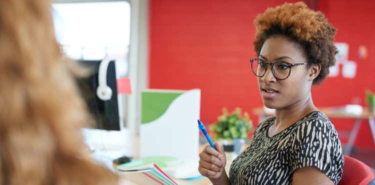 A business woman takes notes in a two-person meeting. A business woman takes notes in a two-person meeting.