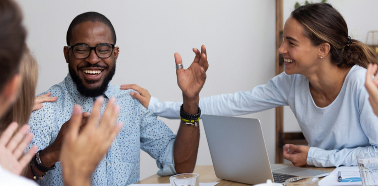 Coworkers congratulate a rising employee in a meeting. Coworkers congratulate a rising employee in a meeting.