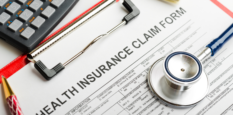 A health insurance claim form and stethoscope. A health insurance claim form and stethoscope.