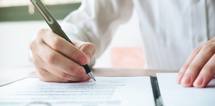 A closeup of a man filling out a form. A closeup of a man filling out a form.