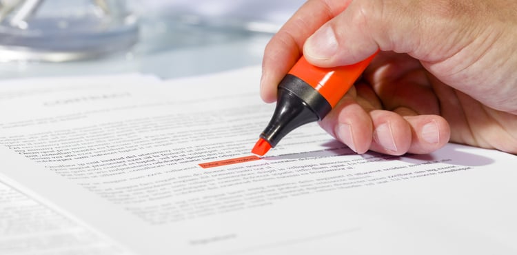 A business man highlights a line in a document. A business man highlights a line in a document.