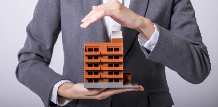 A man holding a model of an office building. A man holding a model of an office building.