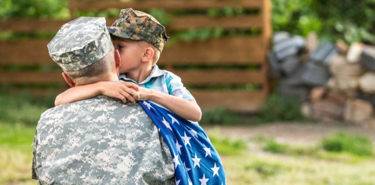 A military father embracing his young son. A military father embracing his young son.