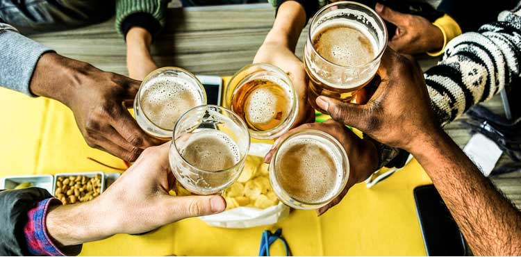 A group of people raise a toast with glasses of beer. A group of people raise a toast with glasses of beer.