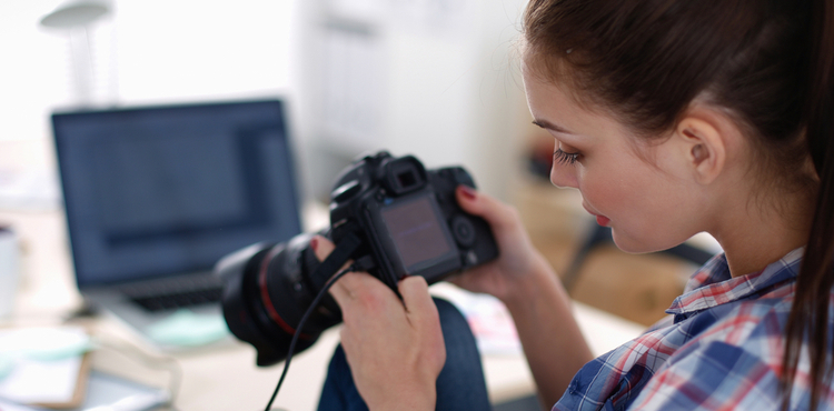 A photographer reviews the photographs on her camera. A photographer reviews the photographs on her camera.