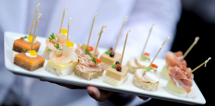 A server presents a plate of appetizers. A server presents a plate of appetizers.