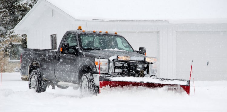 A plow truck clears a driveway in Michigan.