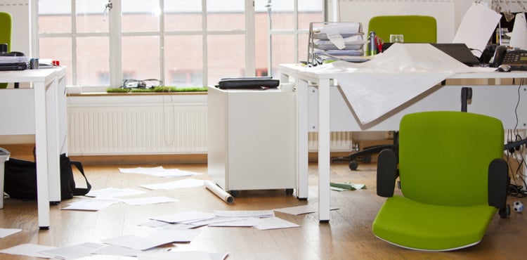 A ransacked office with overturned chairs and scattered documents.