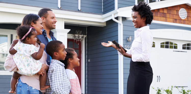 A real estate agent shows a house to a family. A real estate agent shows a house to a family.