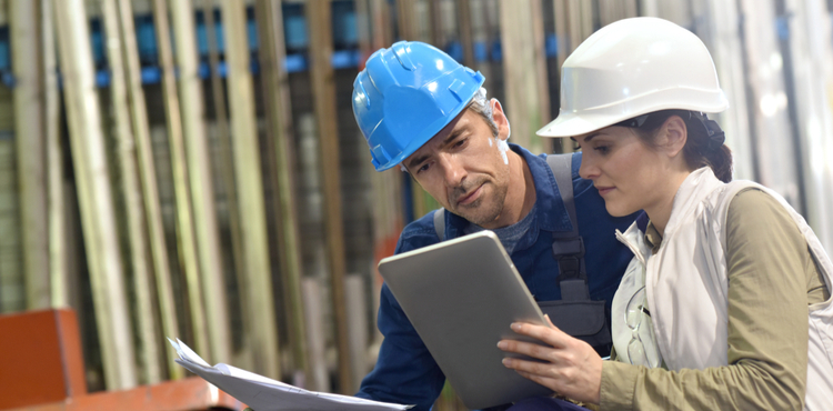 Two engineers read information on a tablet. Two engineers read information on a tablet.