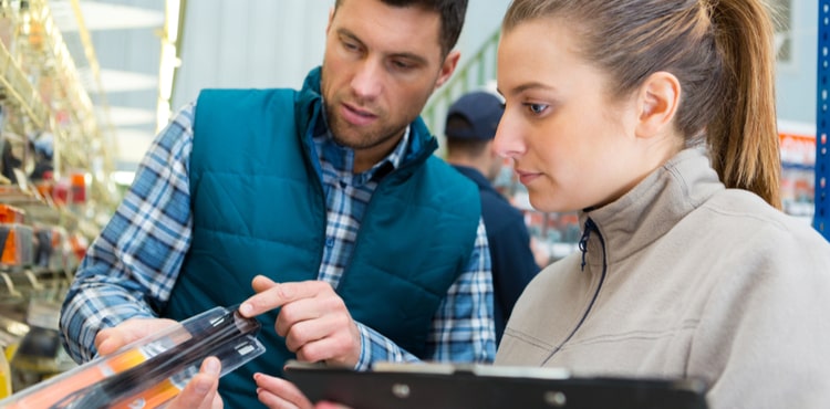 Two people inspect a product in a shop. Two people inspect a product in a shop.