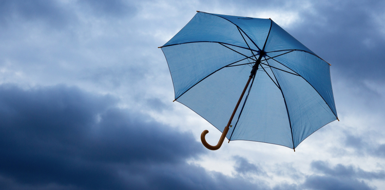 An umbrella blowing away into a stormy sky. An umbrella blowing away into a stormy sky.
