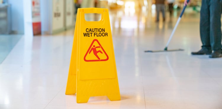 A caution wet floor sign and mop.