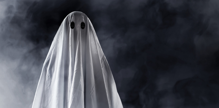 A white ghost stands in front of a black background. A white ghost stands in front of a black background.
