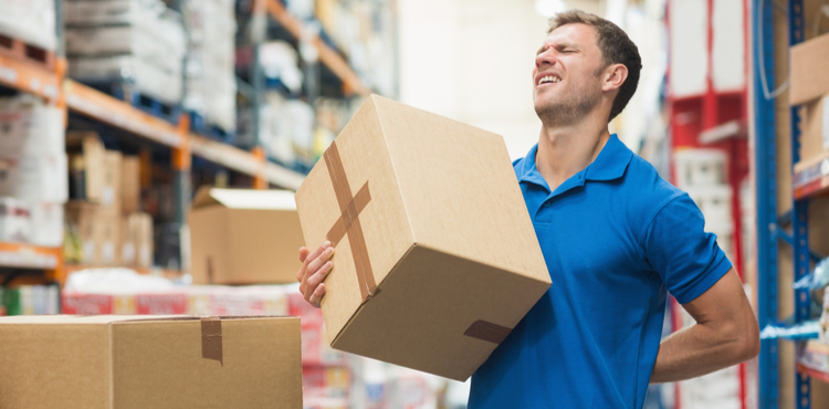 A worker strains his back moving a cardboard box. A worker strains his back moving a cardboard box.