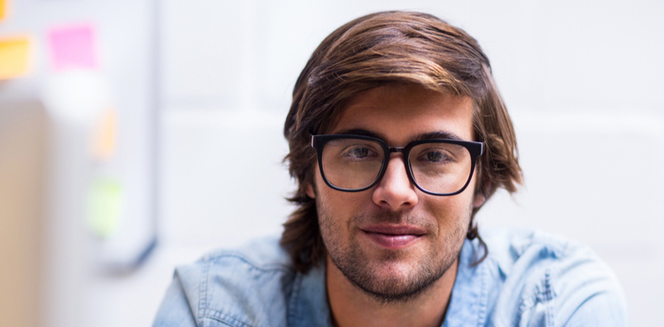 A young man with glasses smiling at the camera. A young man with glasses smiling at the camera.