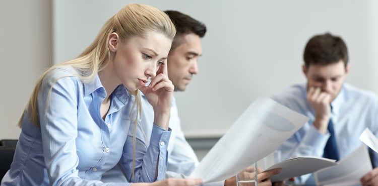 Three frustrated business people read a report. Three frustrated business people read a report.