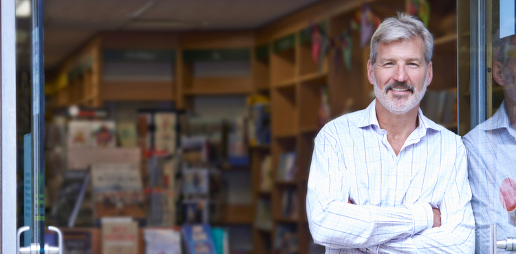 A bookshop owner leaning against the door of his shop. A bookshop owner leaning against the door of his shop.
