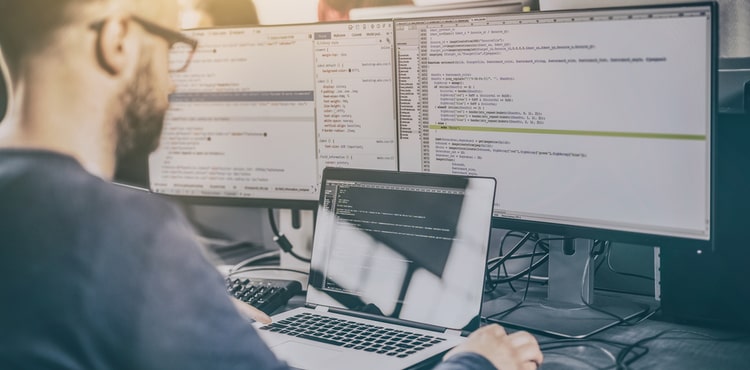 A man working on several screens. A man working on several screens.