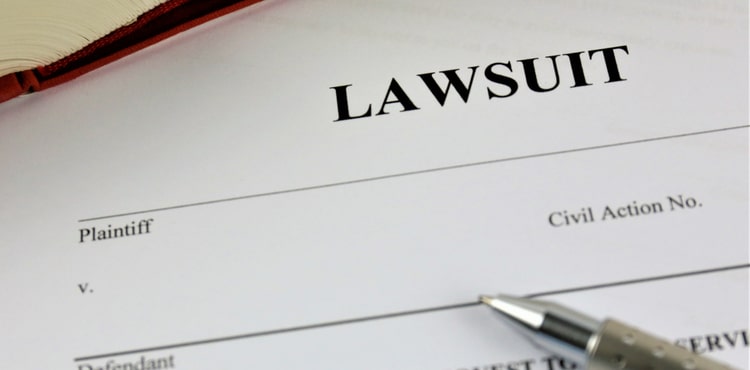 A lawsuit form with a pen lying on top. A lawsuit form with a pen lying on top.