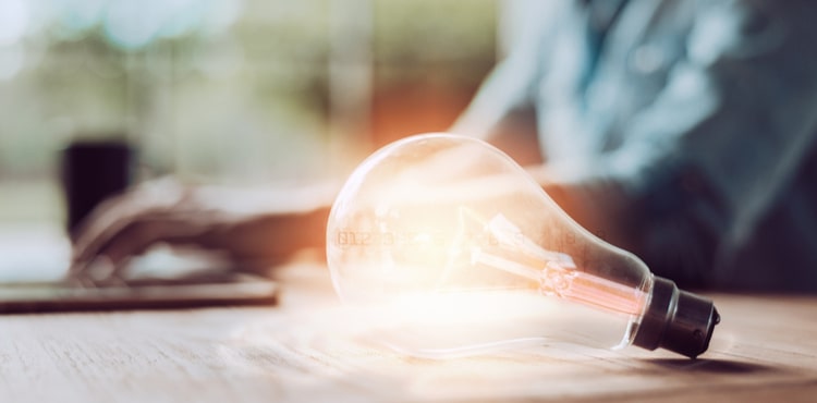 A lightbulb resting on a work desk. A lightbulb resting on a work desk.