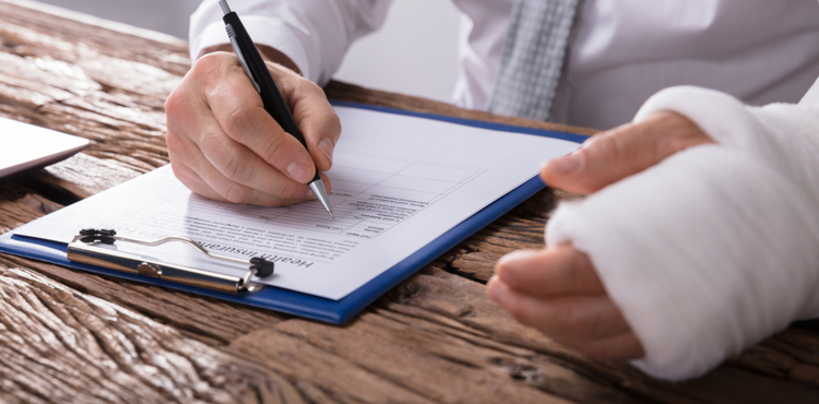 A man with a cast signing a paper. A man with a cast signing a paper.