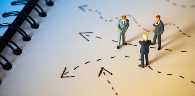 Toy business men standing on a notebook with dashed lines on it. Toy business men standing on a notebook with dashed lines on it.